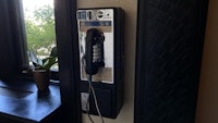 a black telephone next to a window